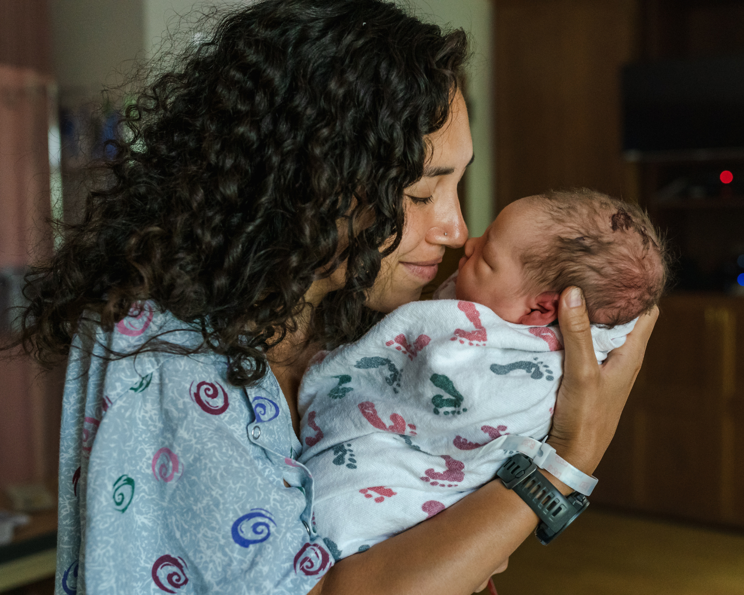 Photo of a new mom holding her new baby face to face while still in the hospital